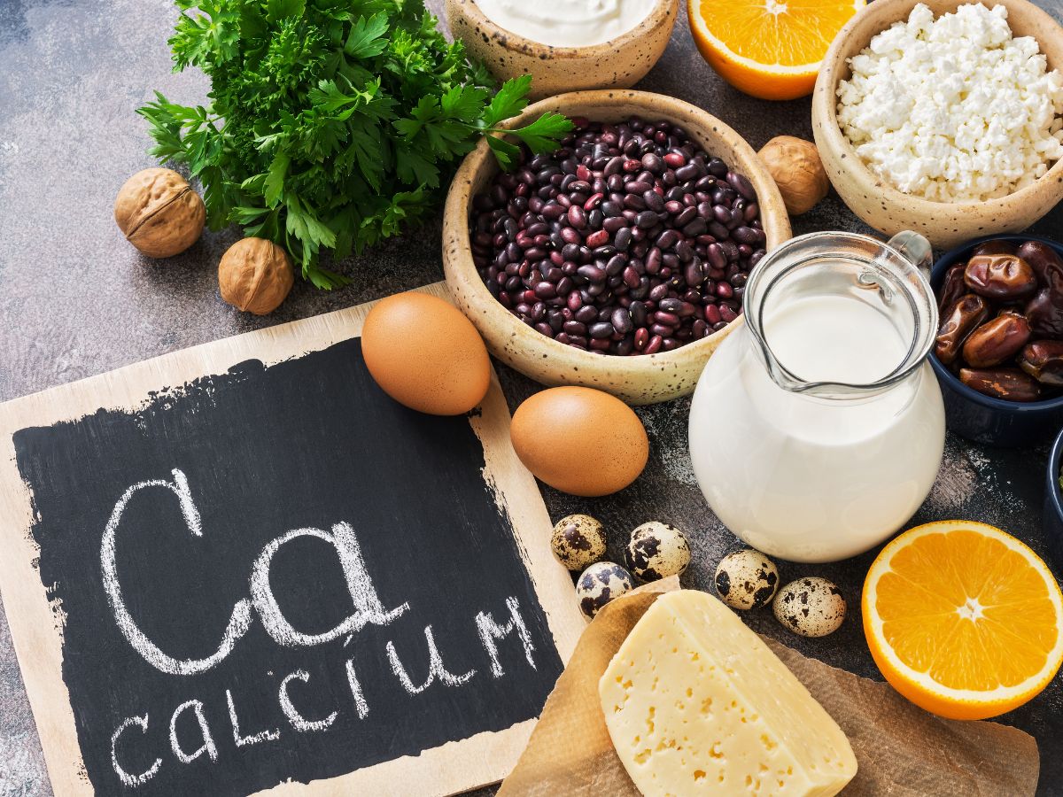 "Calcium" written on a chalkboard and an assortment of foods that are high in calcium