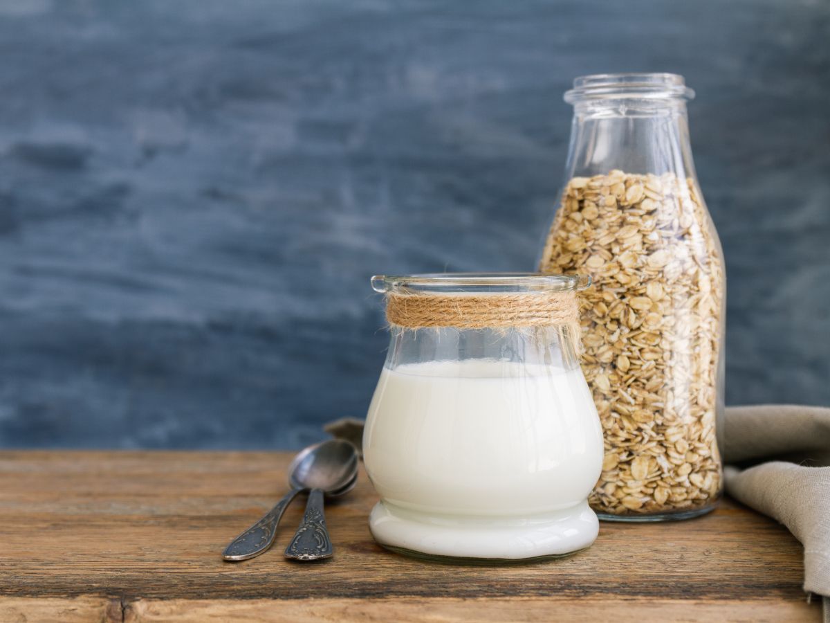 A glass of oat milk and a jar of oats