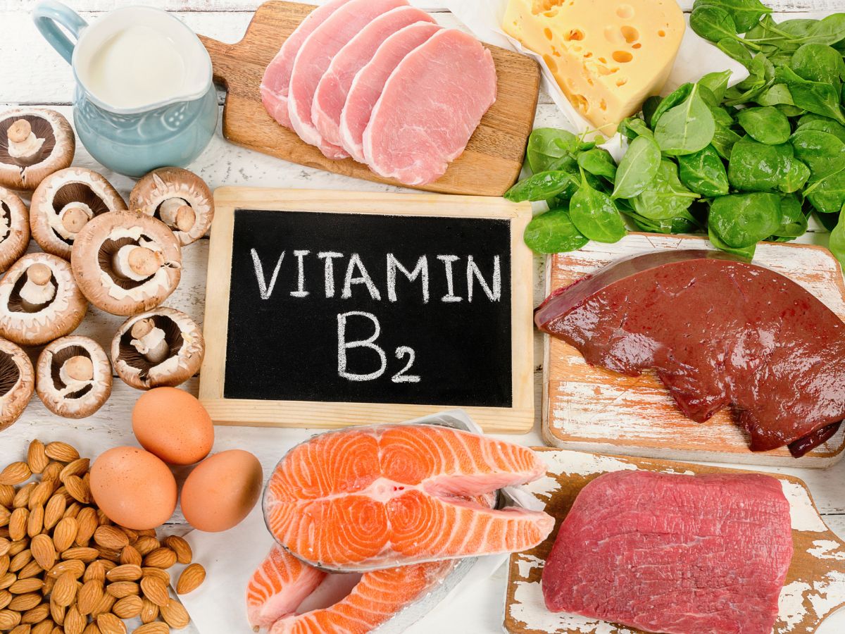 "Vitamin B2" written on a chalkboard and an assortment of foods that are high in riboflavin