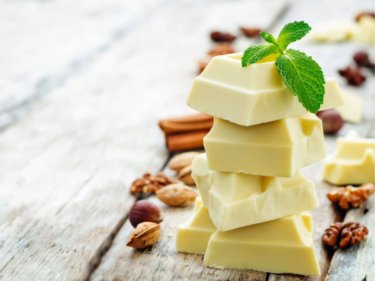 A stack of white chocolate squares surrounded by nuts