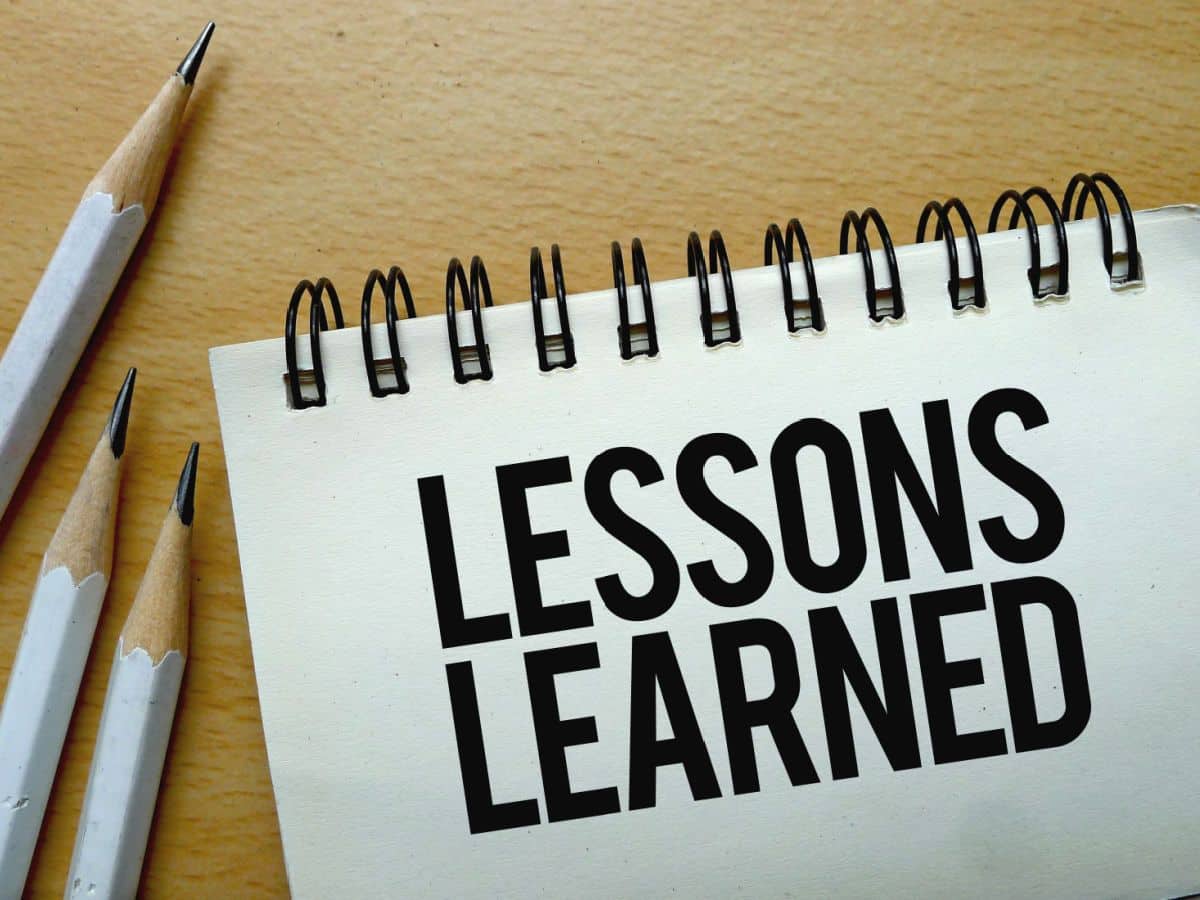 Lessons Learned written on spiral notebook with pencils nearby