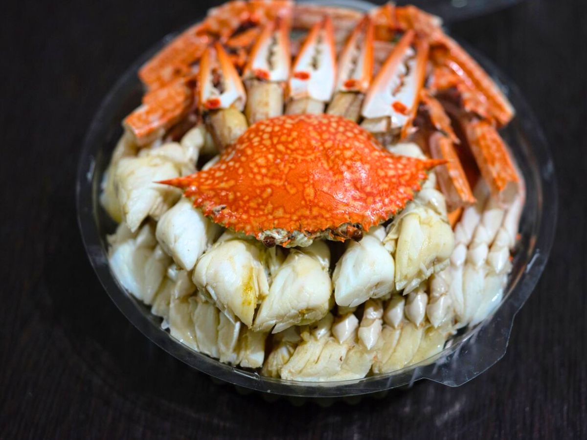Crab meat in a plastic container on a table.