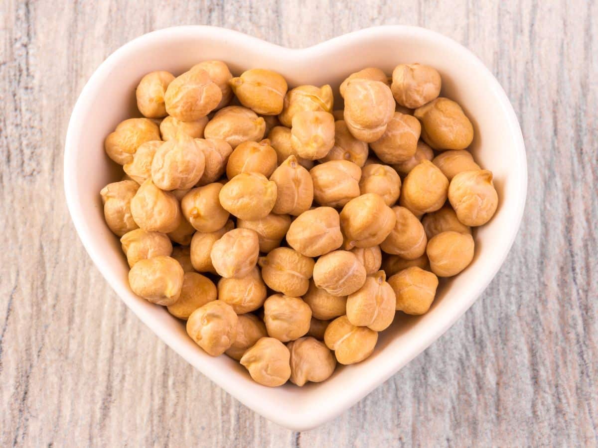 White heart-shaped bowl of dried garbanzo beans (also known as chickpeas)