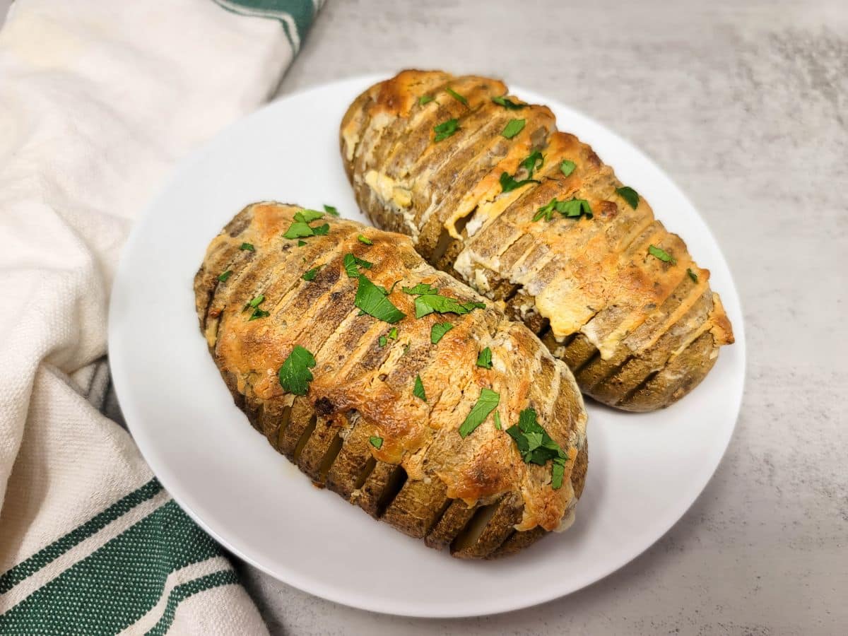 Two large russet potatoes cooked Hasselback-style with Boursin cheese