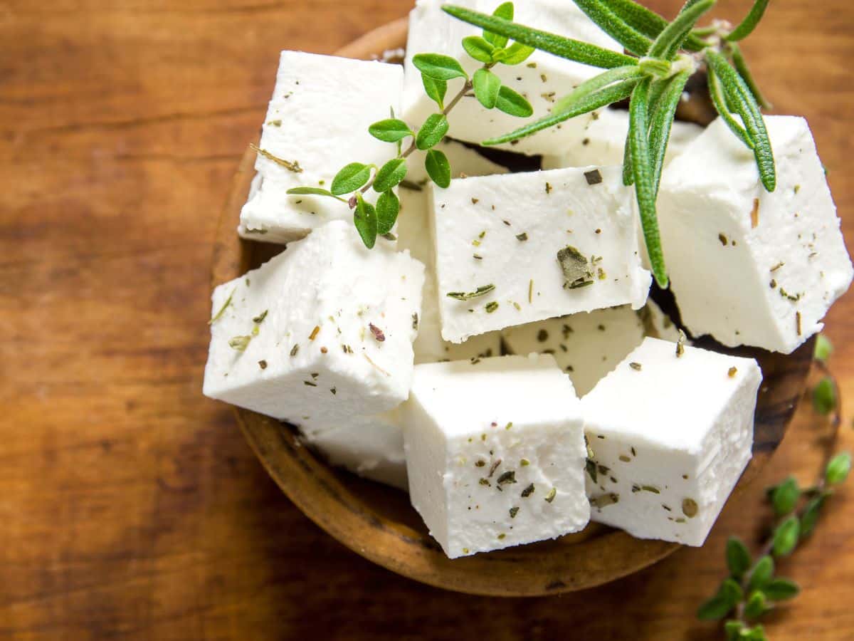 Feta cheese cubes on a wooden plate