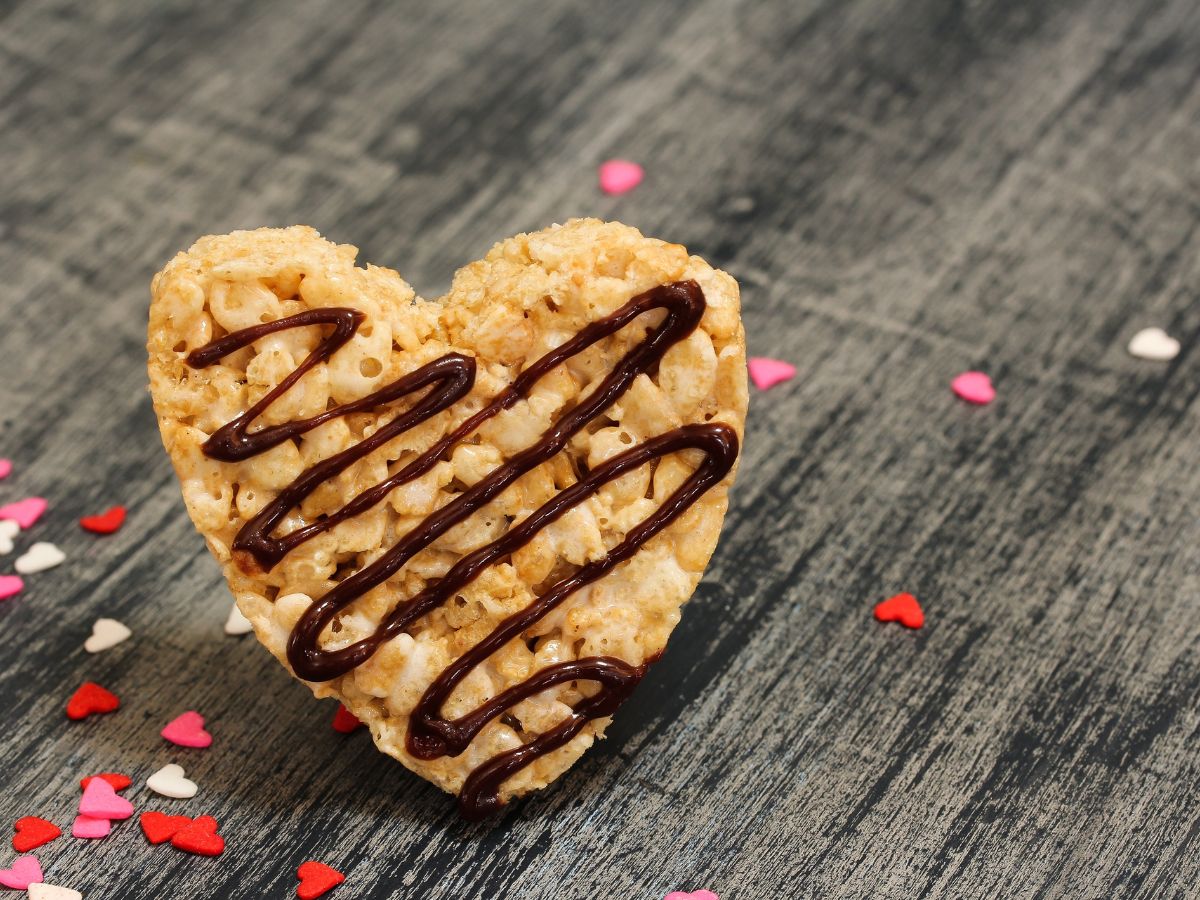 Rice crispy treat cut into a heart and drizzled with chocolate