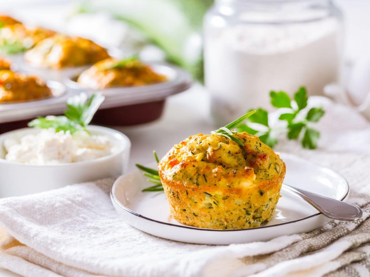 Savory quick bread muffins on a white plate on a linen table cloth