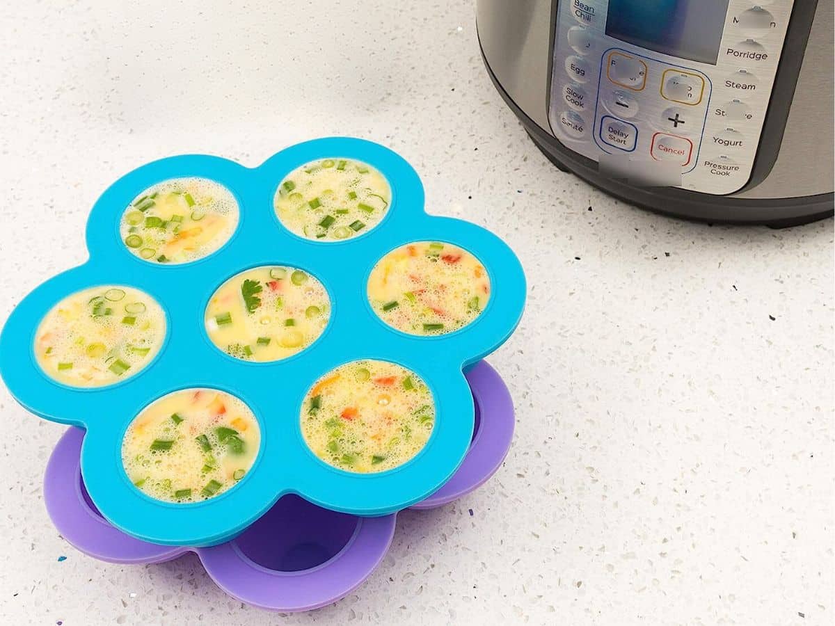 Two stacked silicone egg bite molds by an Instant Pot
