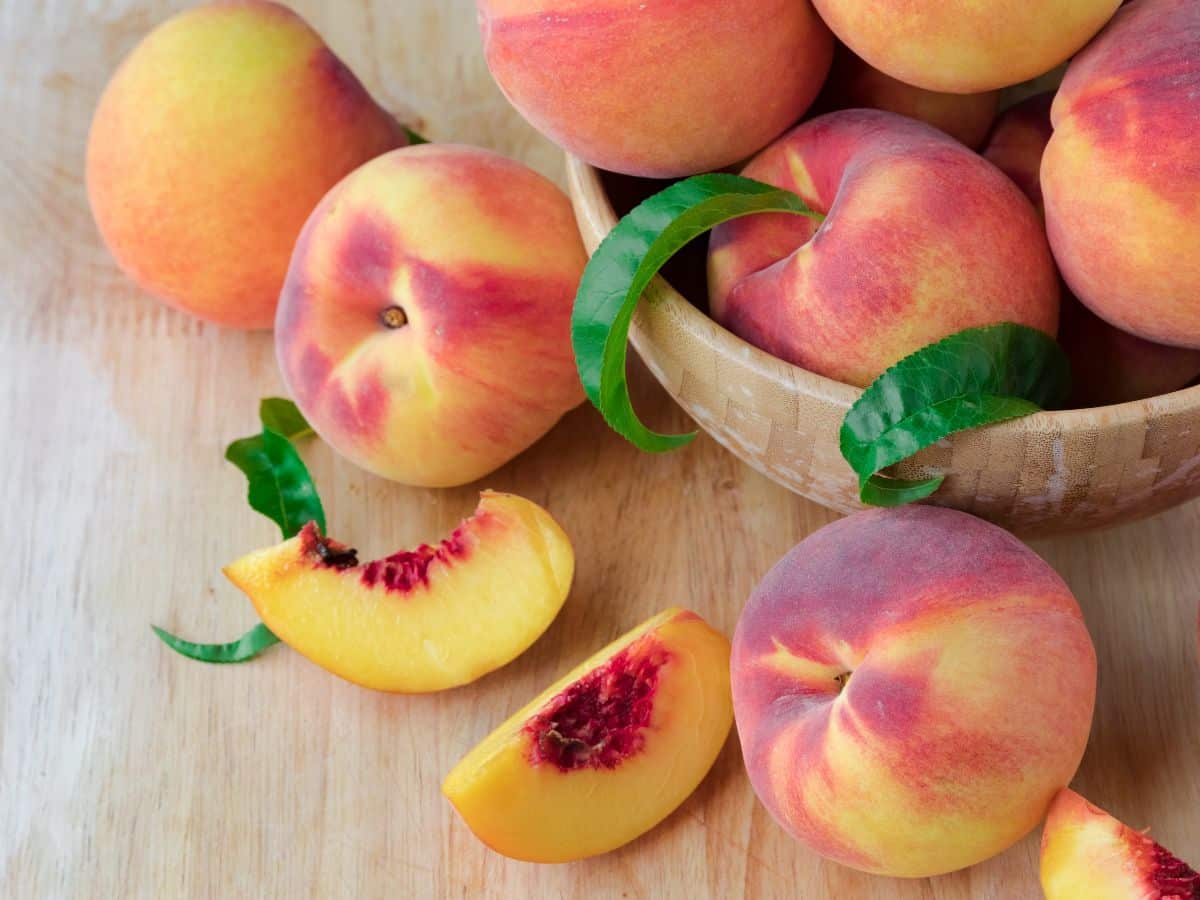 A bowl of fresh peaches on a counter