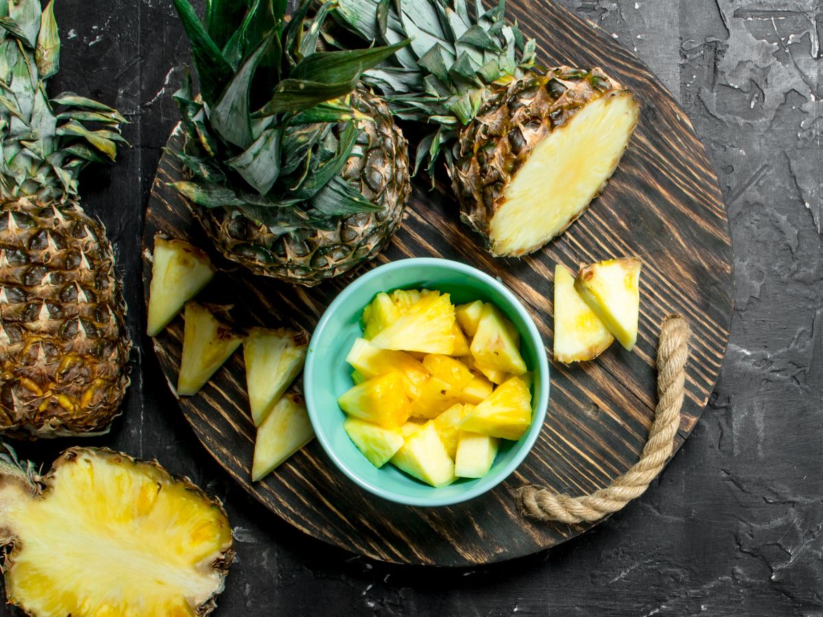 A pineapple cut into chunks on a cutting board