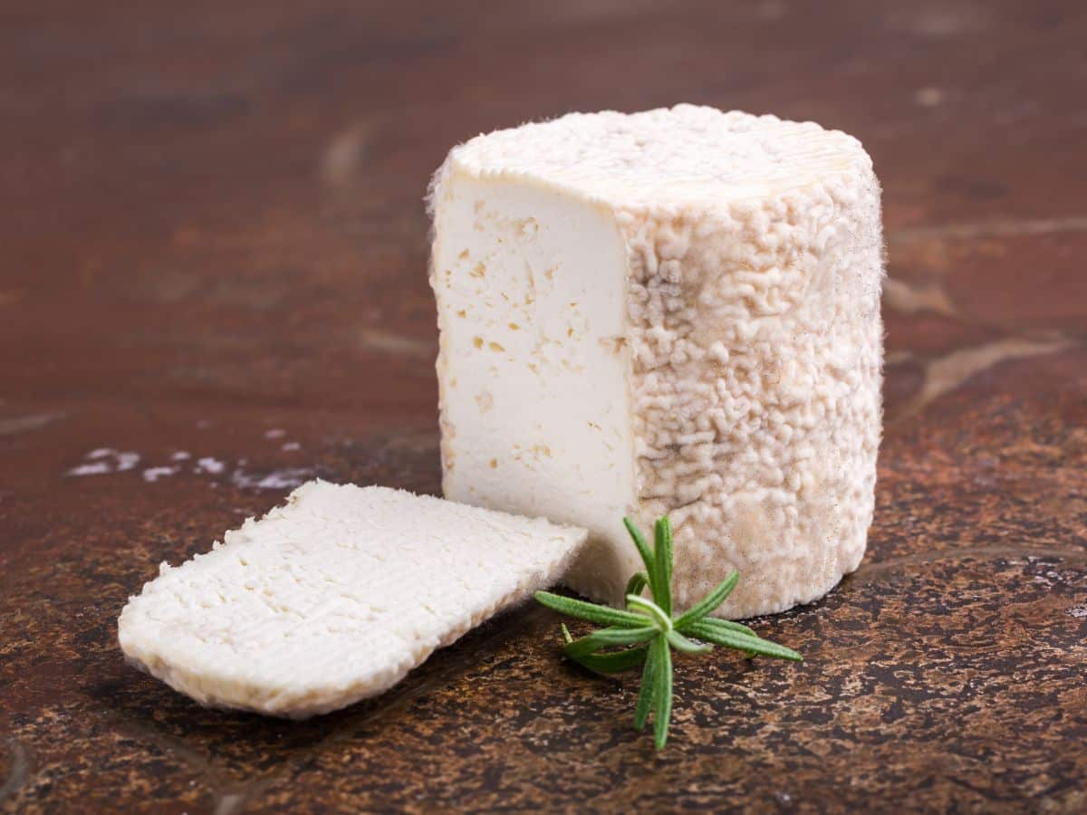 A log of goat cheese, or chevre, on a wooden counter
