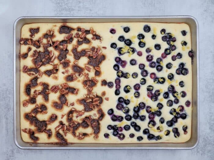 A sheet pan of baked pancakes topped with cinnamon bun and blueberry options
