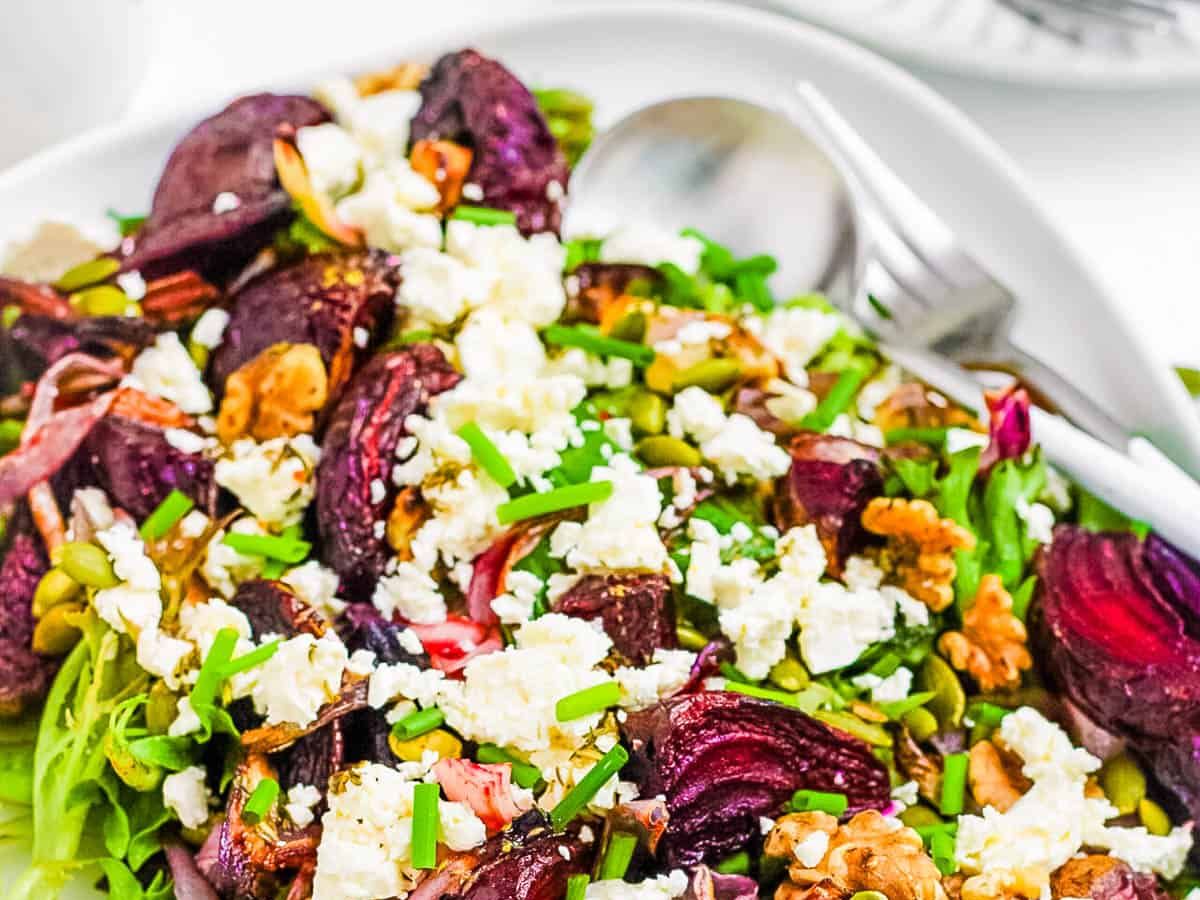 A white platter of beetroot and feta salad ready to be served.