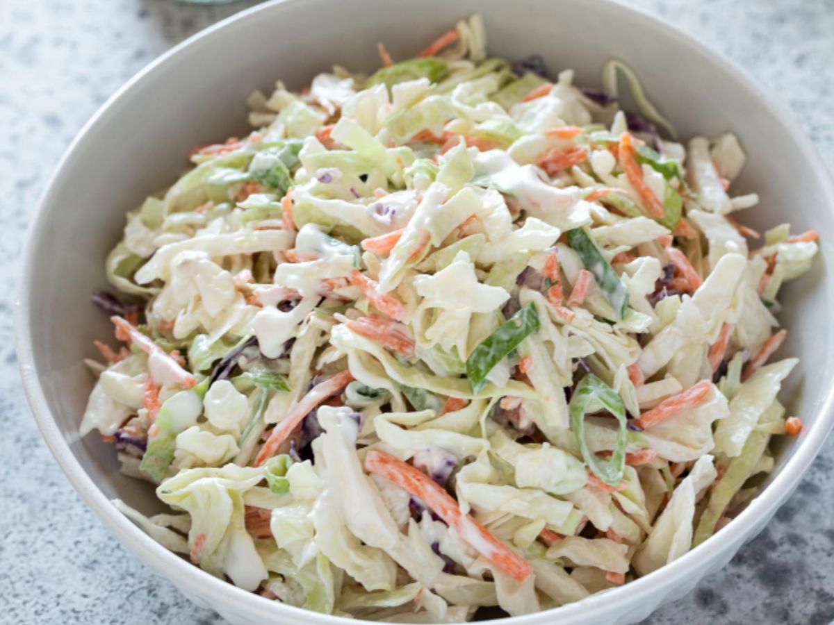 A bowl of classic coleslaw ready to be served at a backyard barbecue.