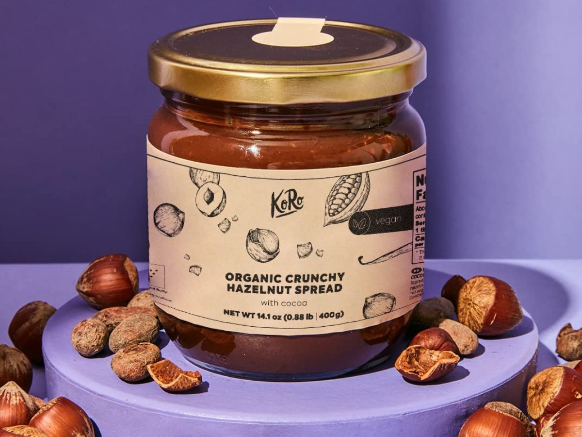 A jar of KoRo Organic Crunchy Hazelnut Spread on a purple background.