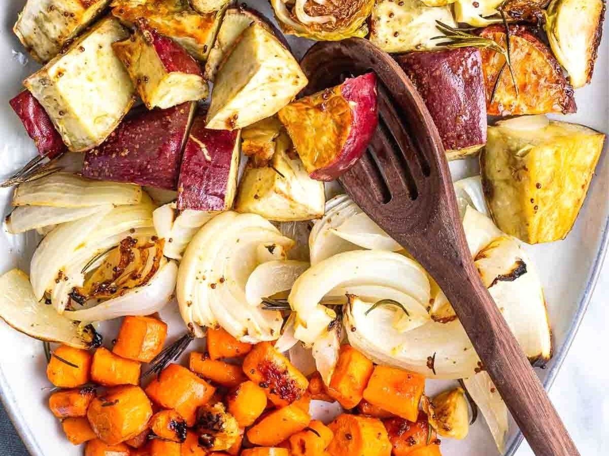 A platter of roasted potatoes, carrots and other vegetables ready to serve.