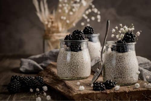 Chia pudding with blackberries on a wooden table.