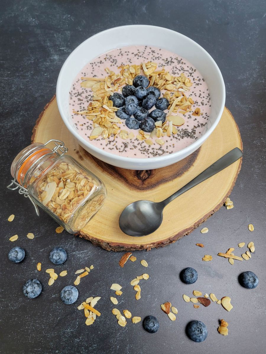A bowl of yogurt with blueberries, chia seeds, and granola.
