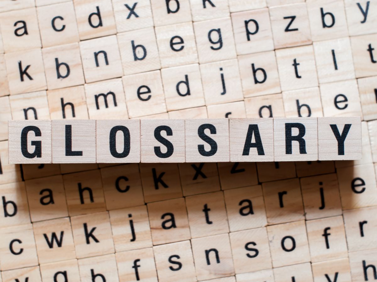 The word glossary is spelled out on a wooden block.