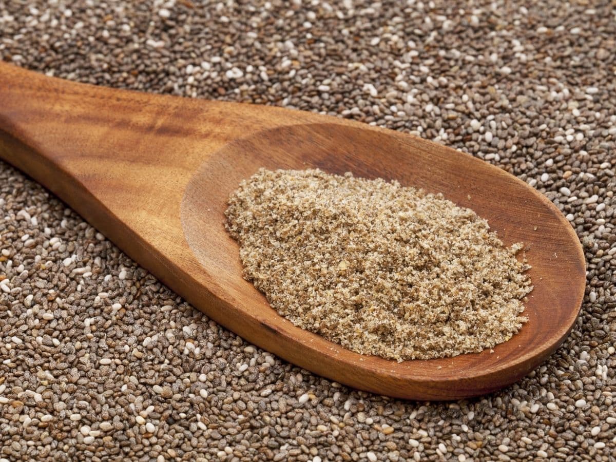A wooden spoon filled with ground chia seeds.