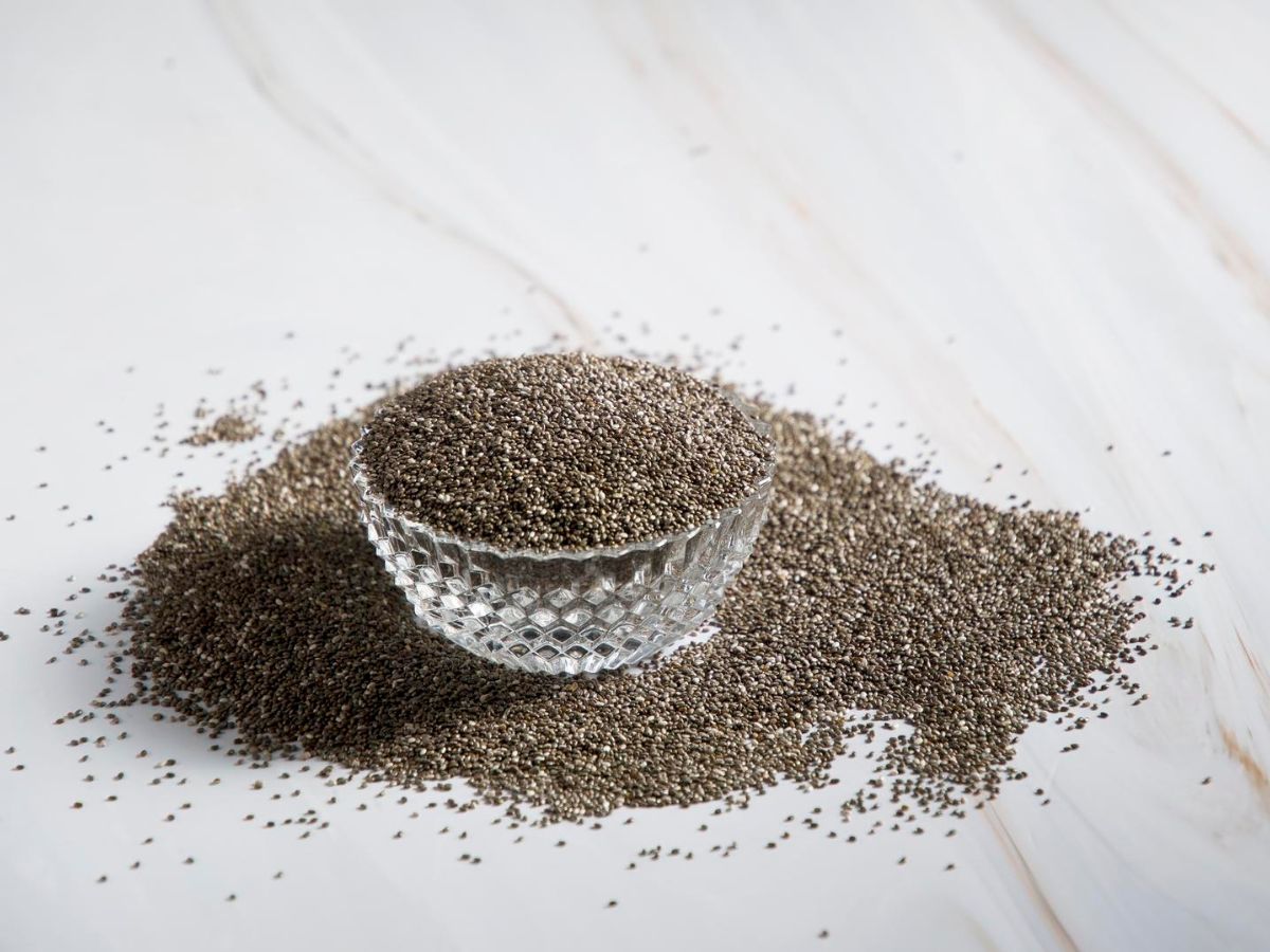 Whole chia seeds in a glass bowl.