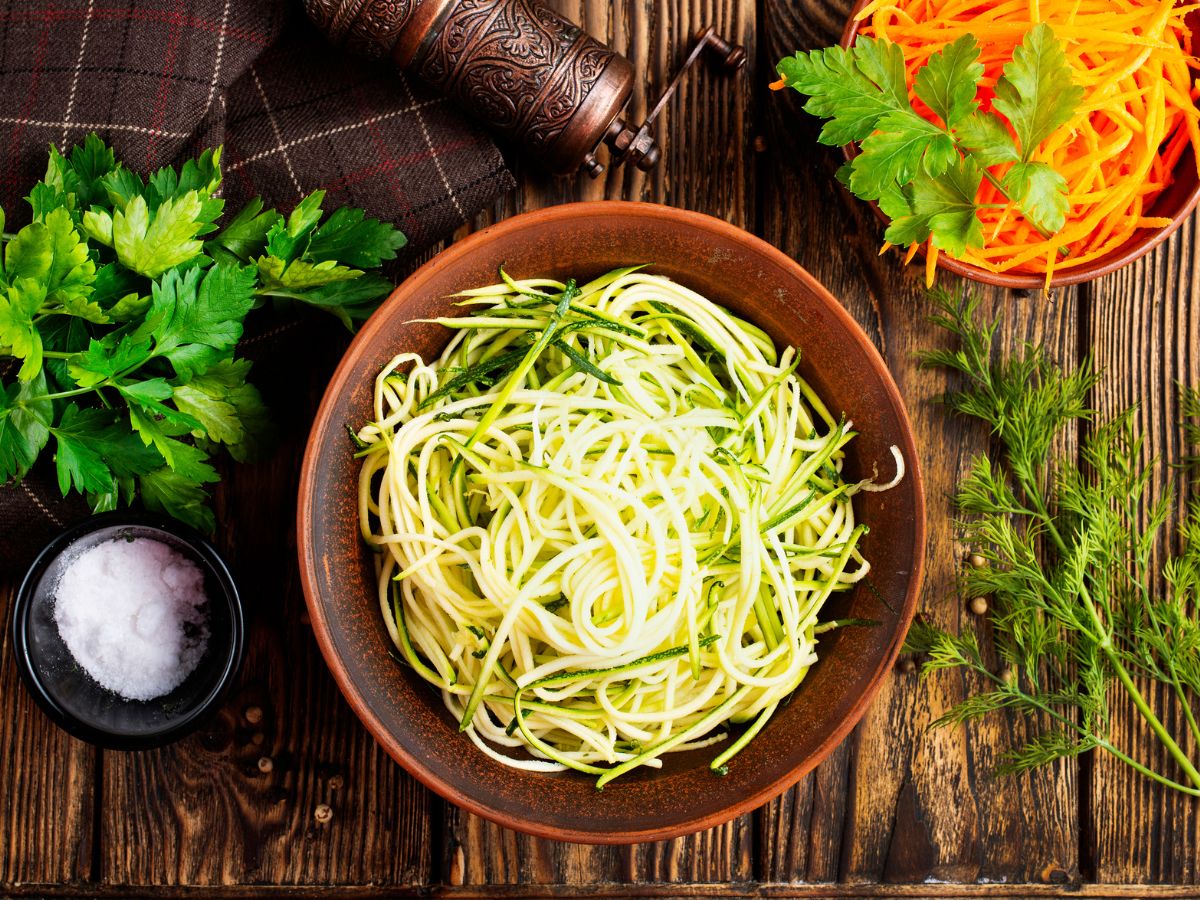 Zucchini noodles in a bowl on a wooden table.