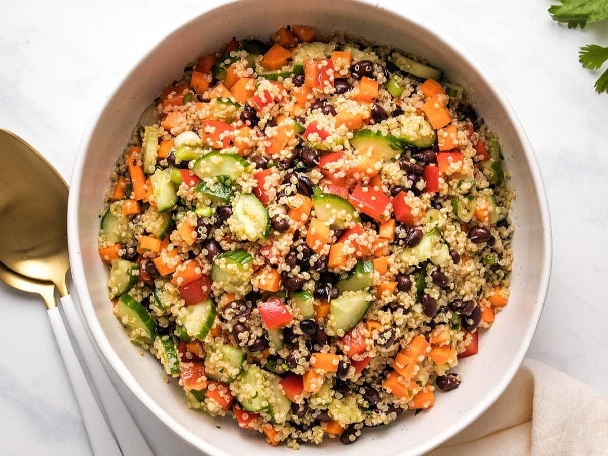 A bowl of quinoa salad with black beans and cucumbers.