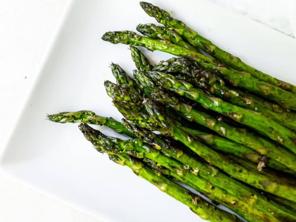Grilled asparagus on a white plate.