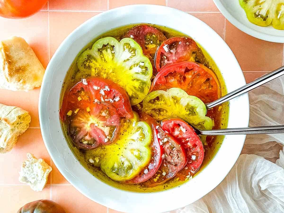A bowl filled with tomatoes and bread.