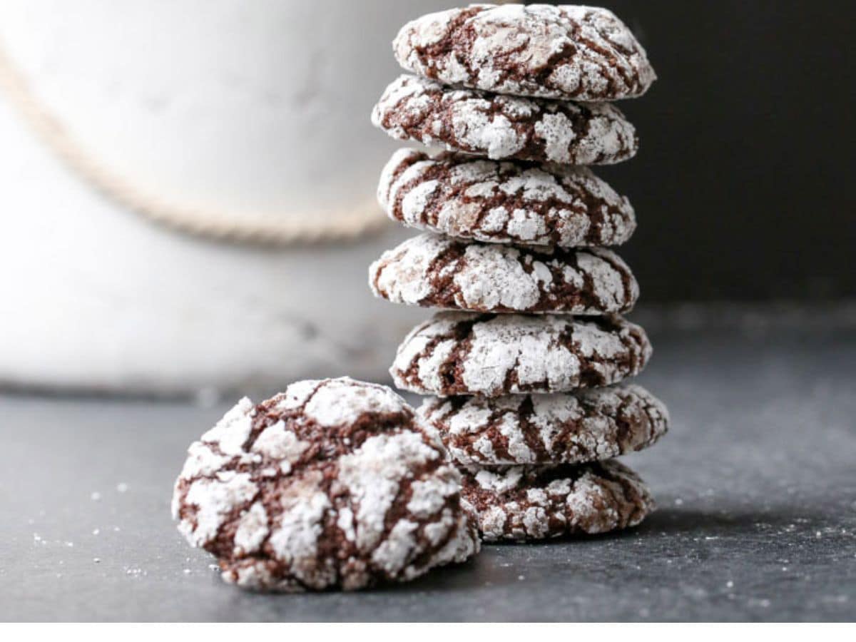 A stack of chocolate crinkle cookies with powdered sugar.