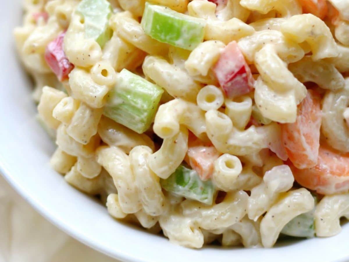 A bowl of macaroni salad with carrots and celery.