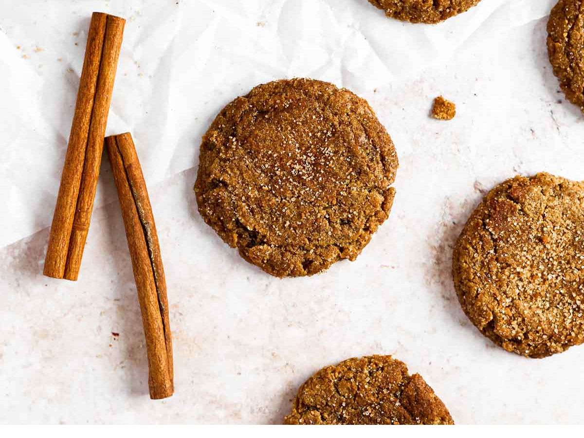 A group of cookies with cinnamon sticks on a white surface.