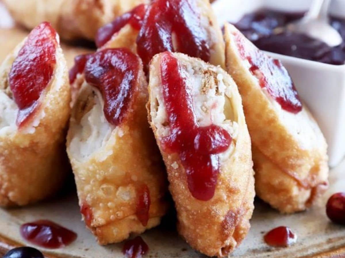 Cranberry turkey spring rolls with cranberry sauce on a plate.
