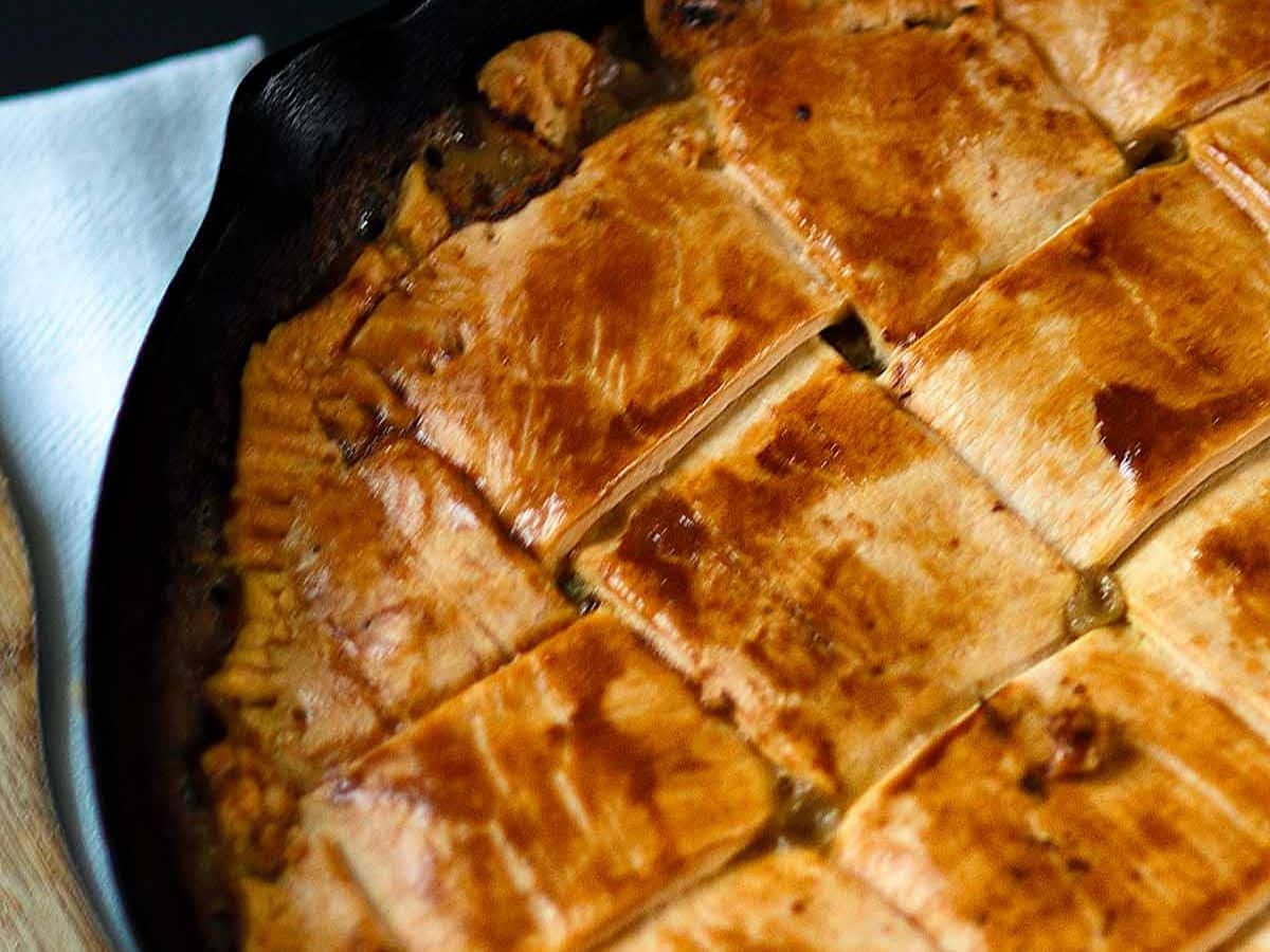 A turkey pie in a cast iron skillet on a table.