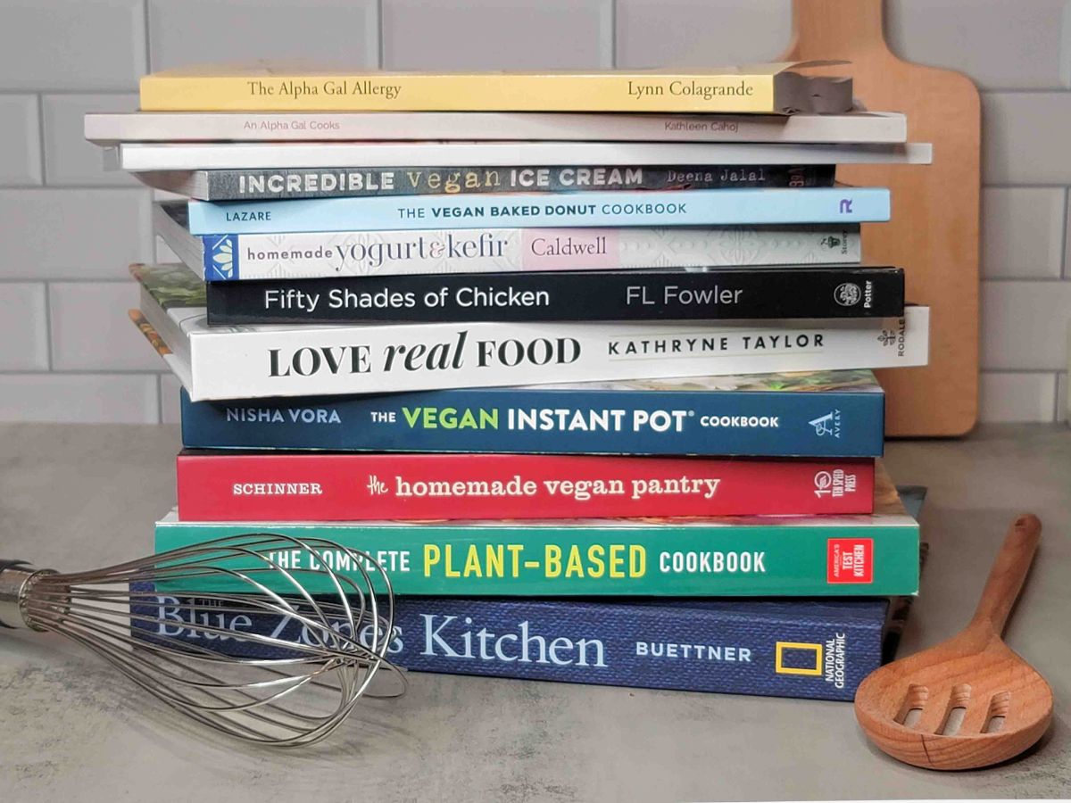 The best cookbooks for alpha-gal syndrome stacked on a kitchen counter.
