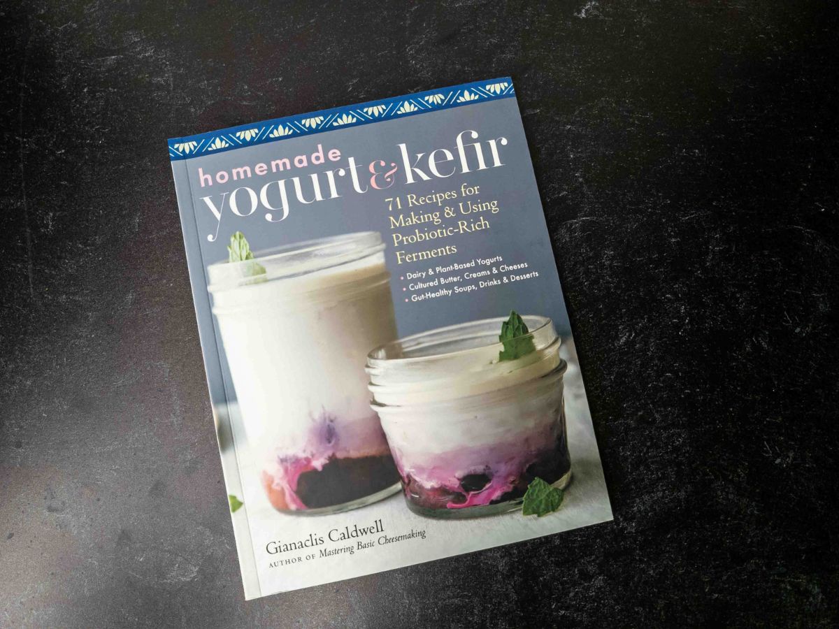 A copy of the Homemade Yogurt & Kefir cookbook on a black slate background.