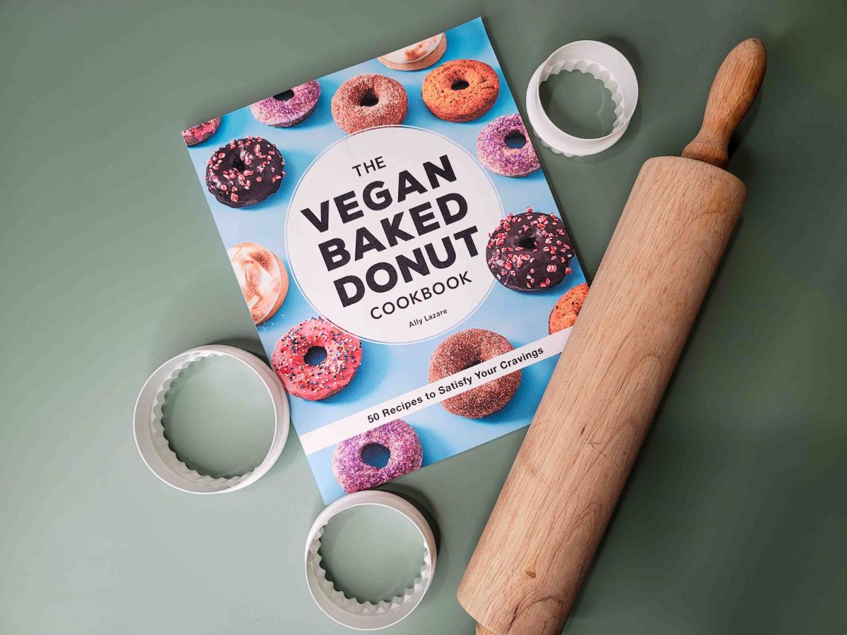 A copy of The Vegan Baked Donut next to donut cutters and a rolling pin.