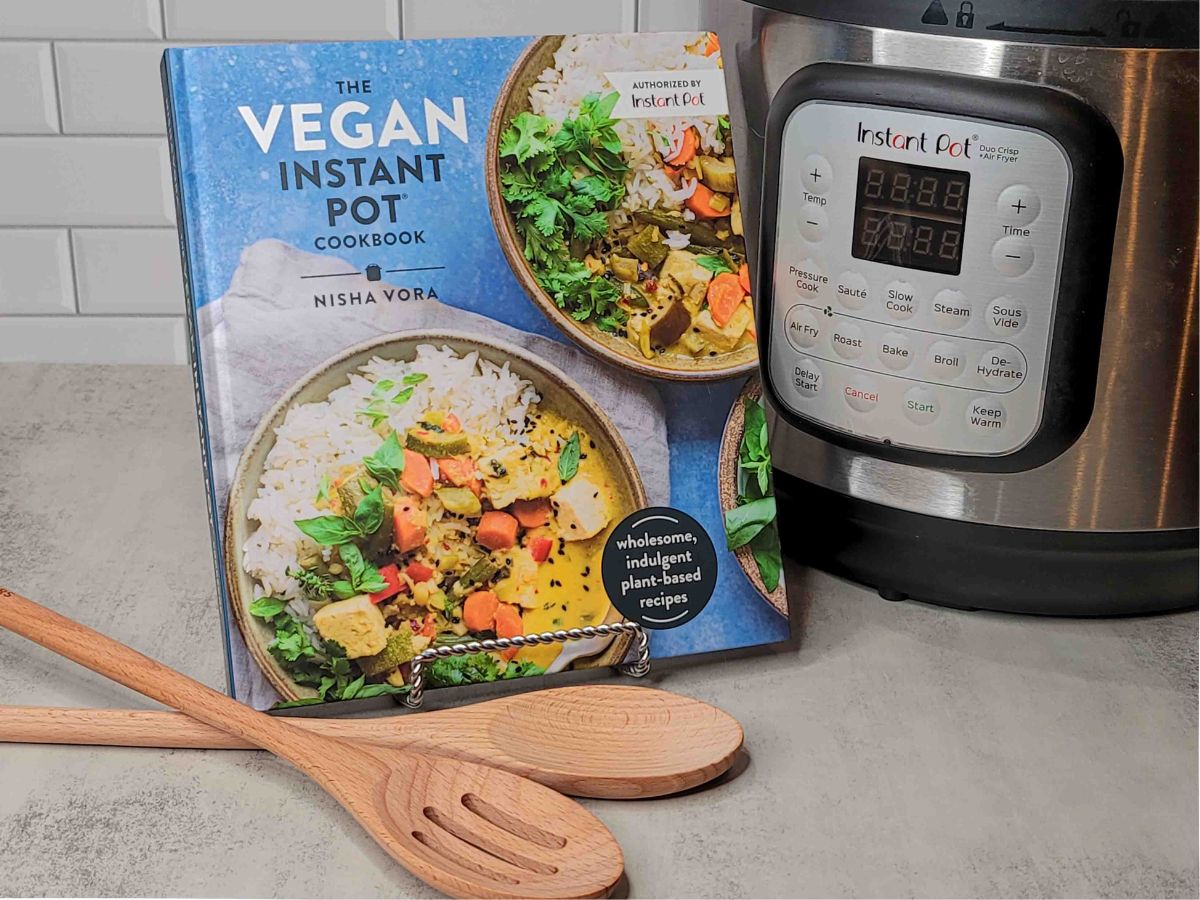 A copy of The Vegan Instant Pot Cookbook next to an Instant Pot.