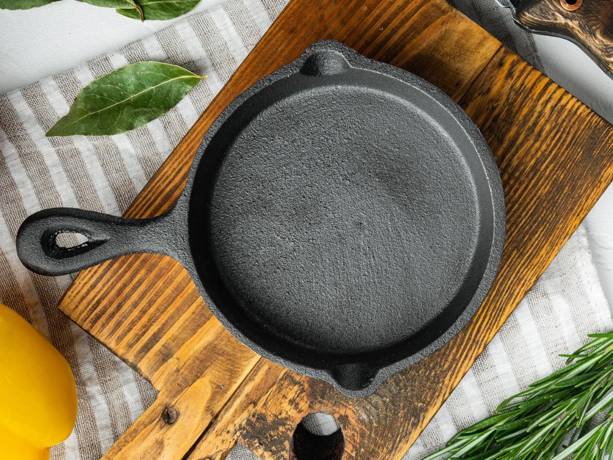 A properly seasoned cast iron skillet on a wooden cutting board.