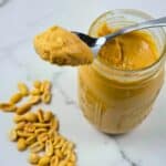 A jar of homemade peanut butter with a spoon.