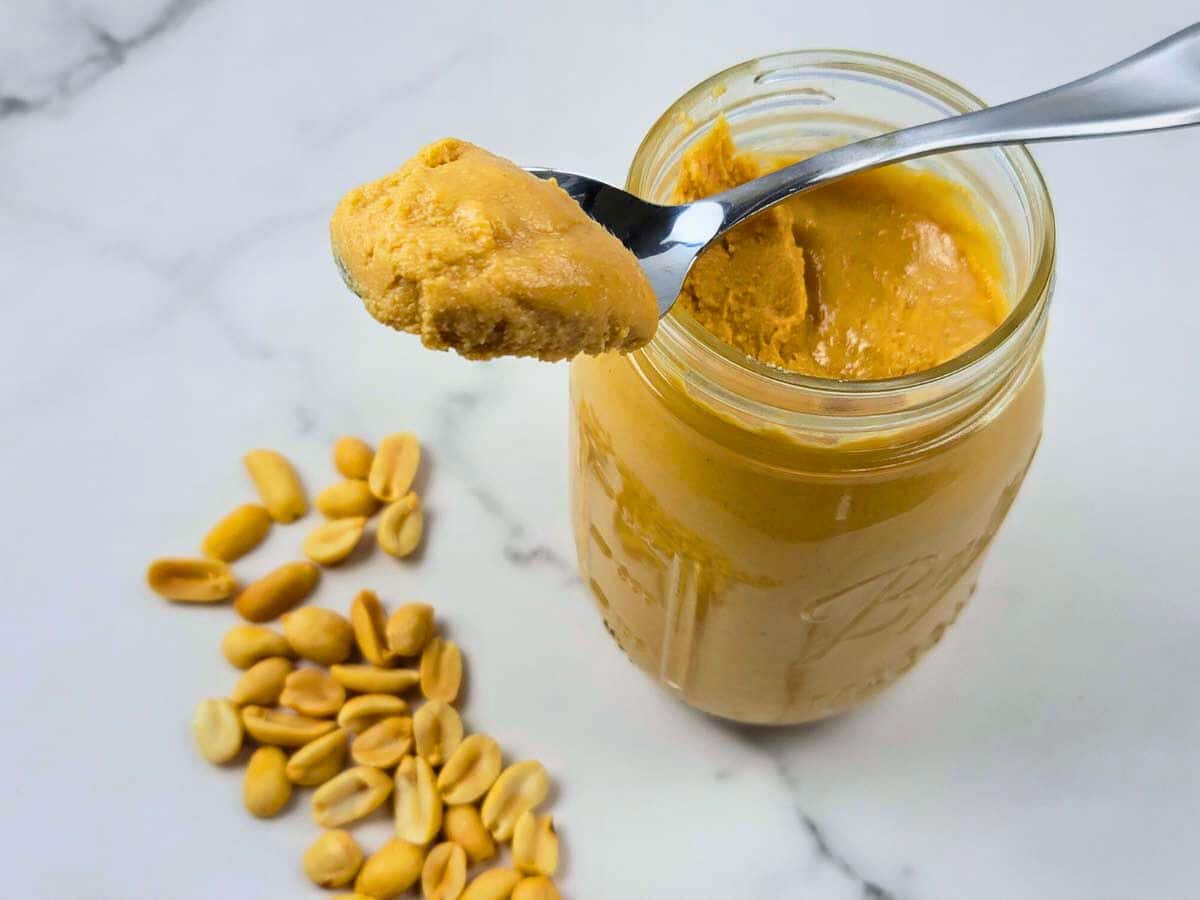 A jar of homemade peanut butter with a spoon.