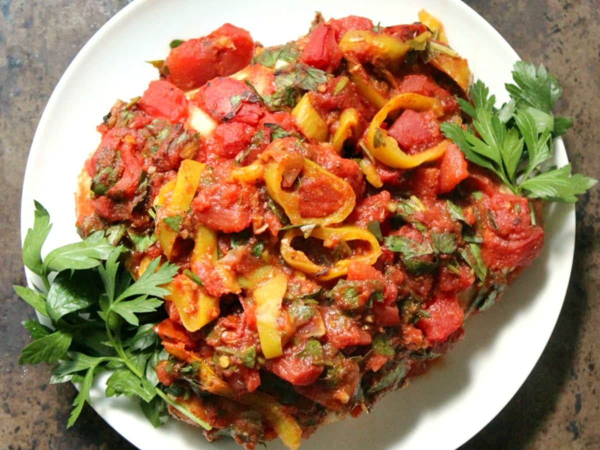 A plate of ratatouille garnished with parsley.