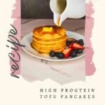 Syrup being poured over a stack of dairy-free protein pancakes garnished with berries on a plate.
